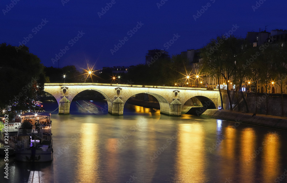 Marie Bridge, between Saint Louis Island and the Quai des Celestins. View from the river Seine at night, Paris.