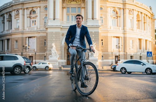 Handsome young man on his bicycle on the street in city center 