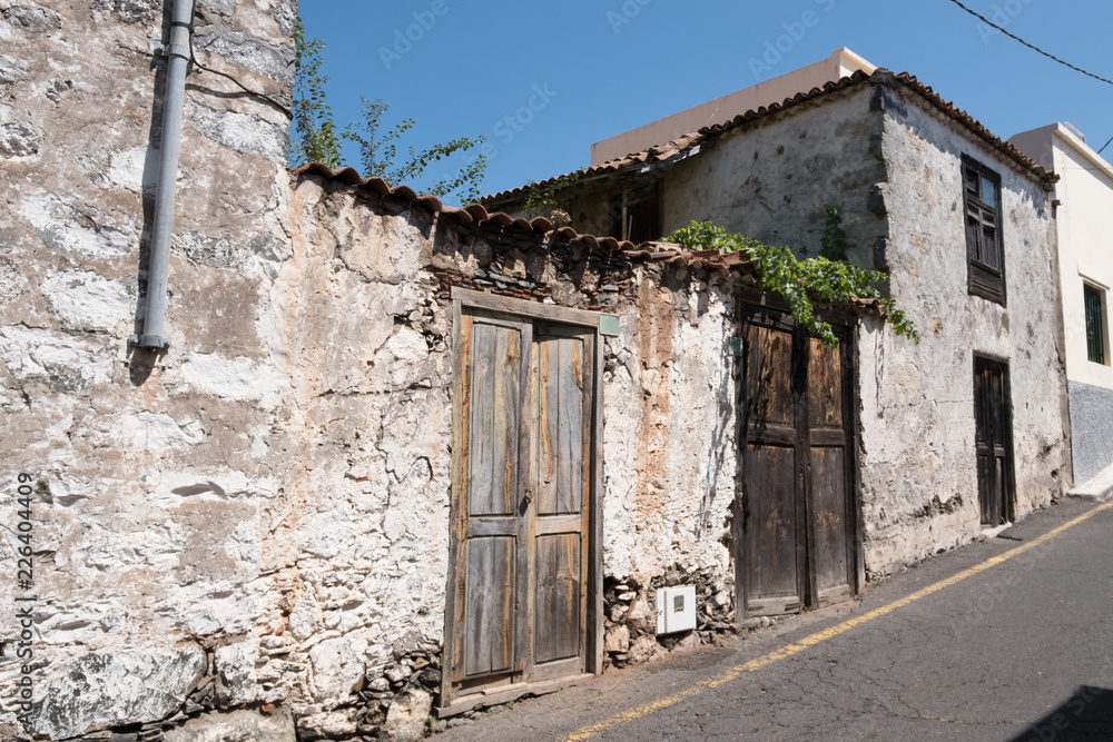 old house  with wooden door and weathered facade in rural village -