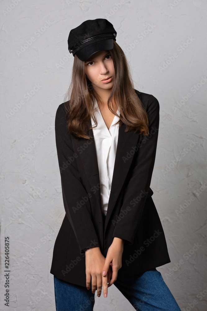 Test shoot of a pretty brunette girl posing in stylish cap, jacket and white blouse Test shoot of a pretty brunette girl posing in stylish cap, jacket and white blouse