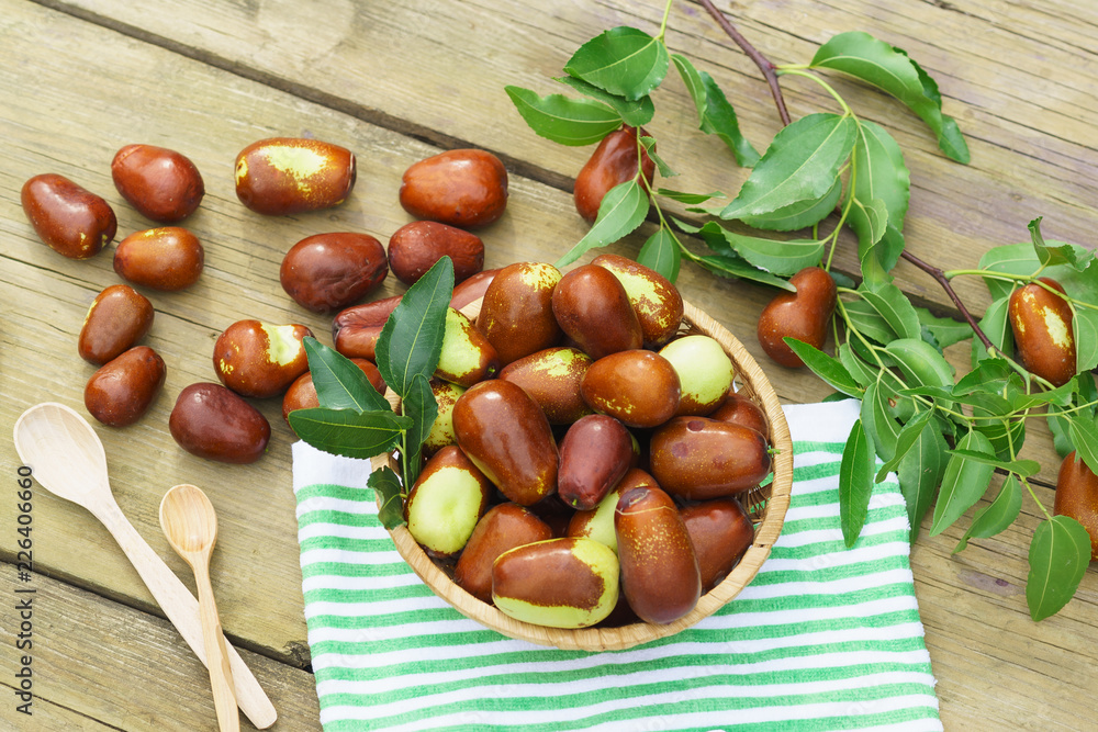 Obraz premium Wicker basket with fruits Ziziphus real, capiente, jujube, Chinese date, capiinit, jojoba, Chinese-date (lat.Ziziphus jujuba) on the table