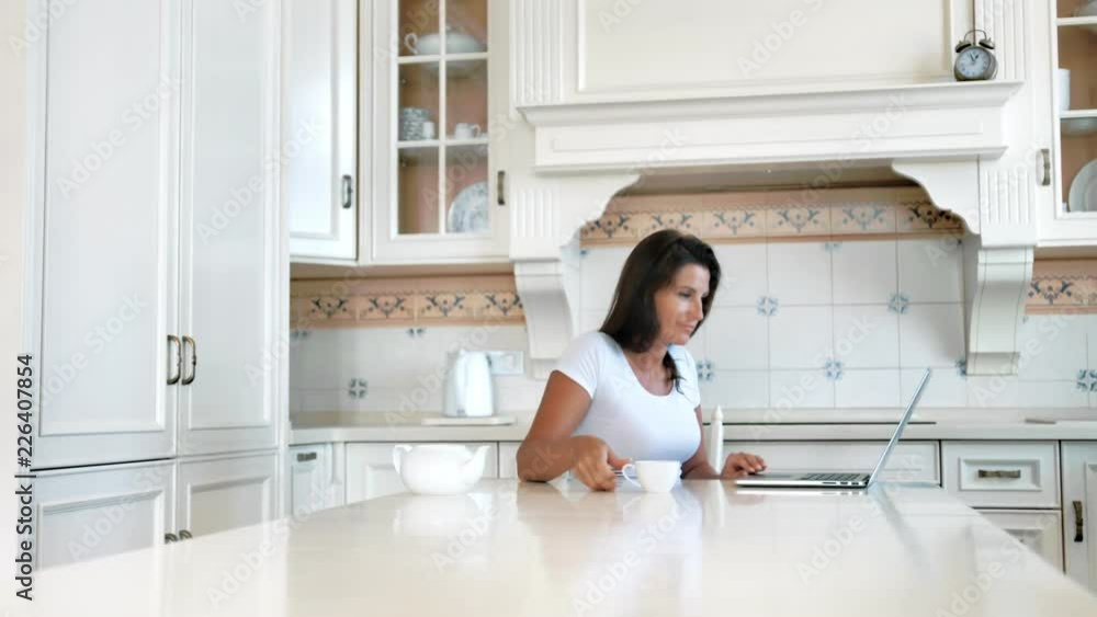 Smiling freelancer woman working writing text using laptop at vintage home kitchen Smiling freelancer woman working writing text using laptop at vintage home kitchen