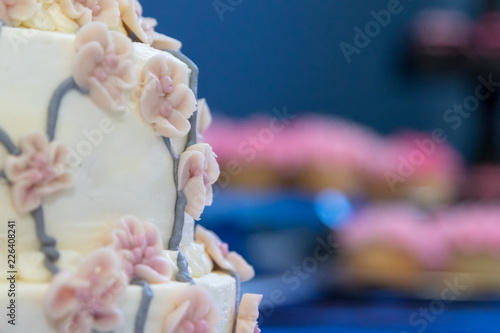 wedding cake closeup blurred pink cupcakes background