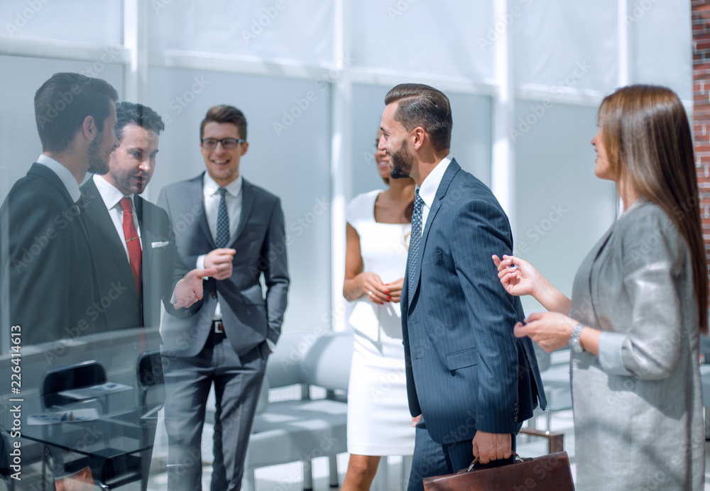 employees discuss business documents standing in the office employees discuss business documents standing in the office