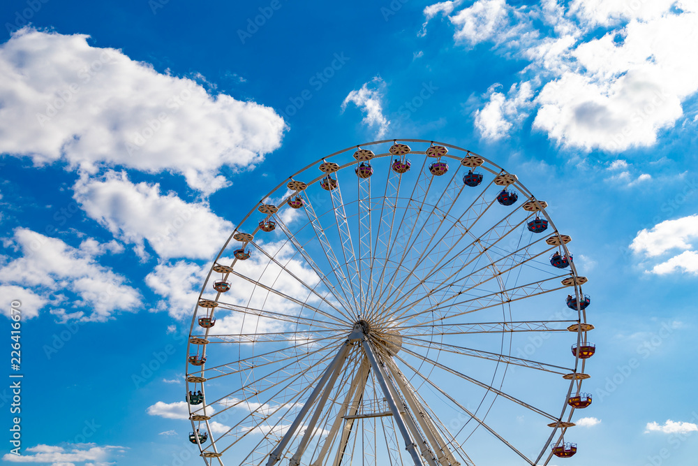 Ferris wheel on a fairground in front of a blue sky