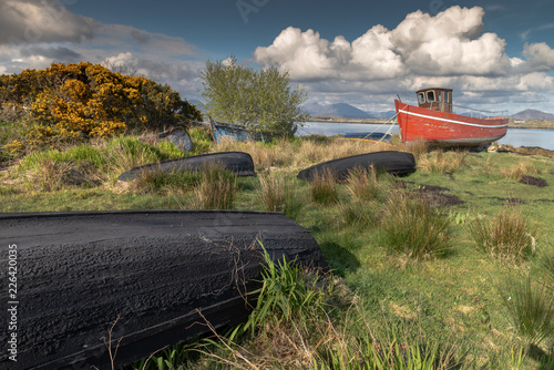 Derelict fishing boats , left to decay on the beach, Roundwood Ireland. Wooden - Red