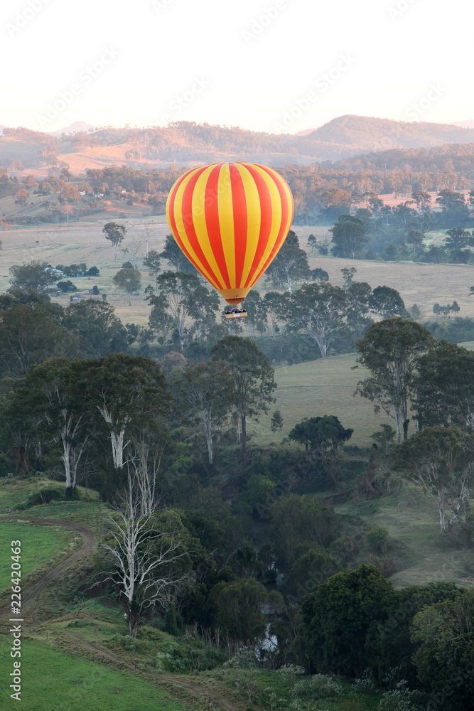 Naklejka premium Hot Air Balloon flight over Gold Coast Hinterland, Queensland, Australia at sunrise in mid winter