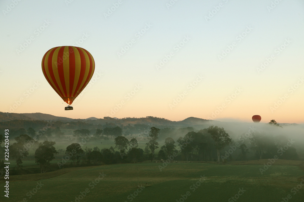 Naklejka premium Hot Air Balloon flight over Gold Coast Hinterland, Queensland, Australia at sunrise in mid winter