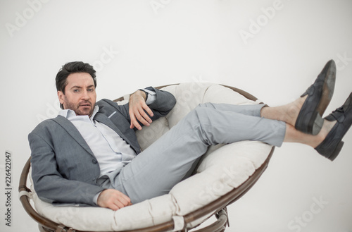 close up.the tired man relaxarea in a large round chair