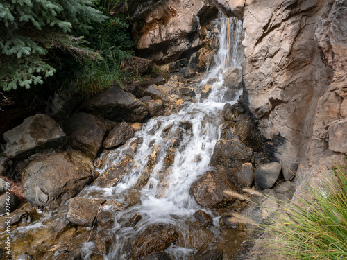 A mountain spring waterfall flowing and tumbling down the rocks