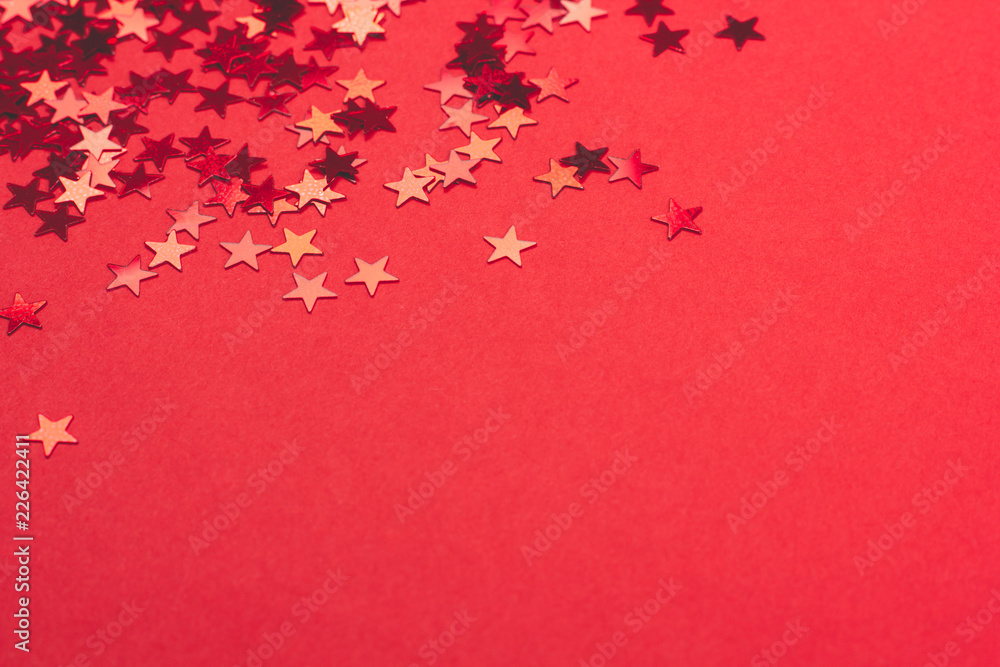 Metallic confetti on festive red paper background. Metallic confetti on festive red paper background.