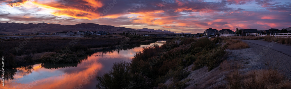 Wide banner panorama of a clorofuls sunset reflecting off the river