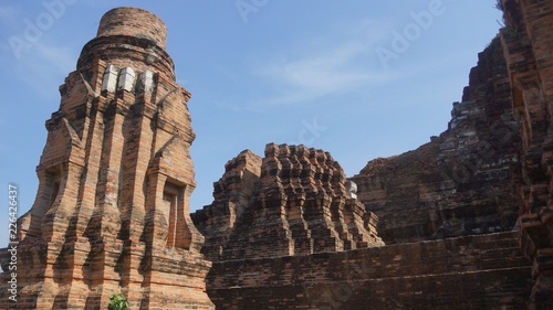 Buddhist temple with ruins, colorful shrines & a famed Buddha head surrounded by tree roots - Wat Phra Mahatat