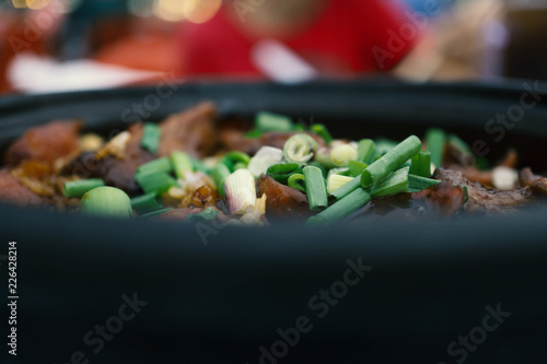 Malaysian food, blur clay pot rice with green vegetable slice in black pot photo