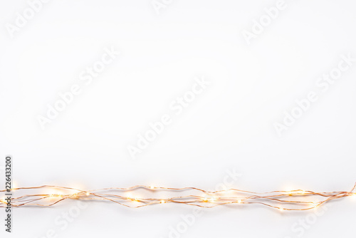 Obraz na płótnie Christmas lights garland border over white background. Flat lay, copy space. w salonie
