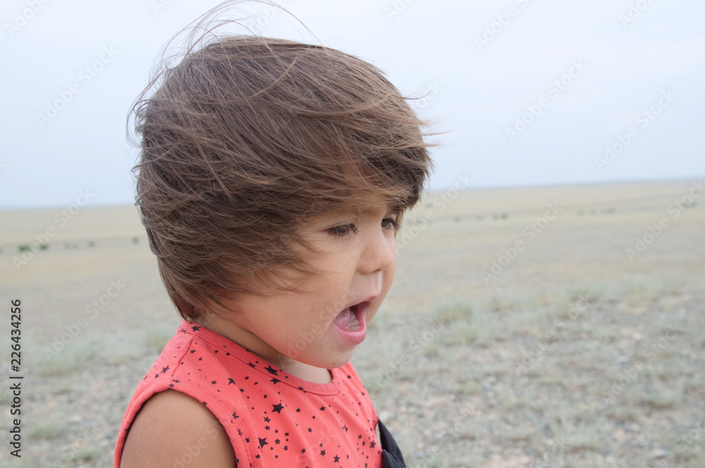 Little girl happy smiling in big landscape environment. Child emotionally with expression playing outdoor Little girl happy smiling in big landscape environment. Child emotionally with expression playing outdoor