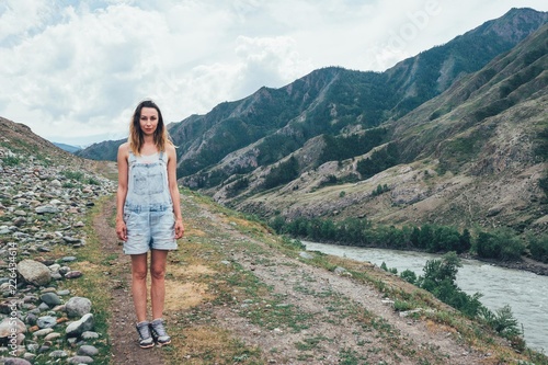 A girl stands on the rocks in the mountains