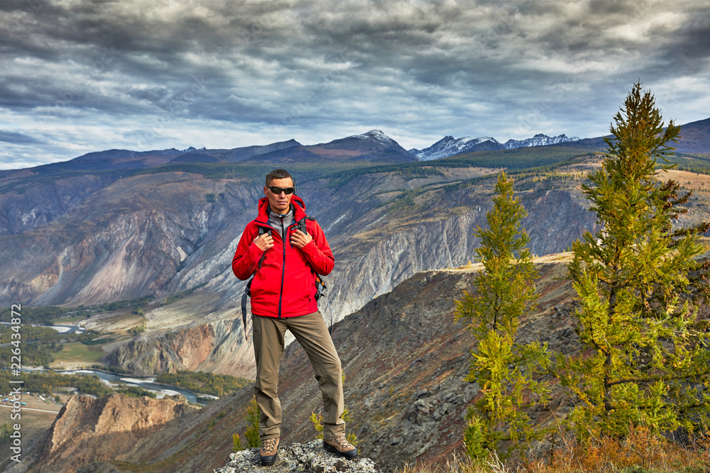 Young Man Traveler relaxing outdoor with rocky mountains on background Autumn vacations and Lifestyle