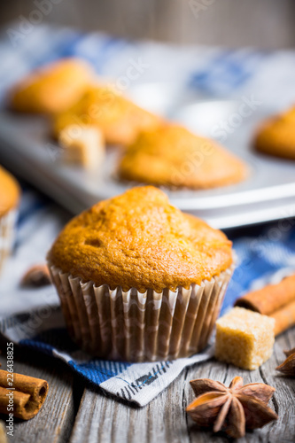 Homemade atutumn muffins with pumpkin, apples and spices on the rustic background. Selective focus.  photo