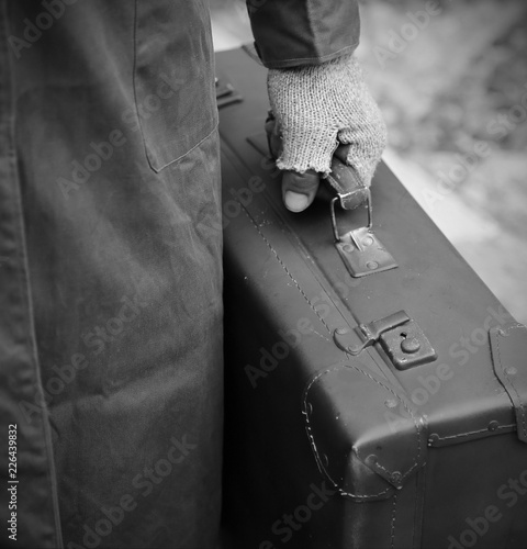 Fényképezés poor traveler with worn leather suitcase with black and white effect