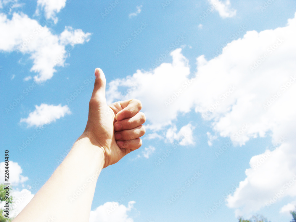 people and body parts concept - african woman hands showing thumbs up over blue sky and clouds background people and body parts concept - african woman hands showing thumbs up over blue sky and clouds background
