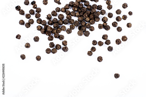 Black pepper corns on white background