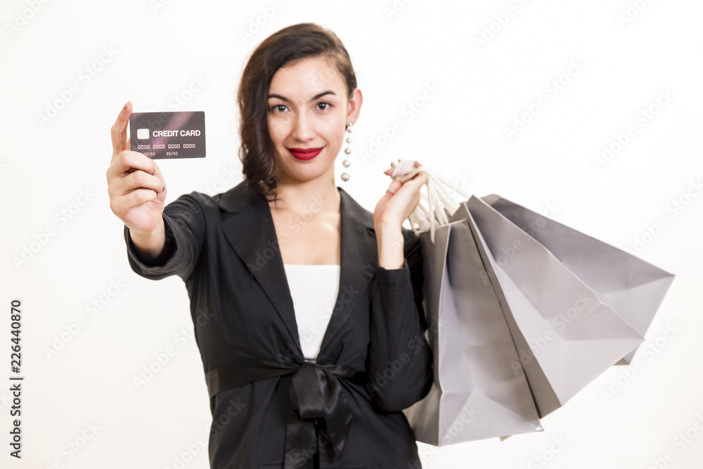Shopping online with credit card concept. Closeup of woman holding shopping bags and credit card with free space for text on white background. Shopping online with credit card concept. Closeup of woman holding shopping bags and credit card with free space for text on white background.