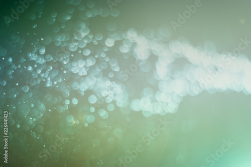 Blurred abstract bokeh light of fly water background, Christmas two tone colors.
