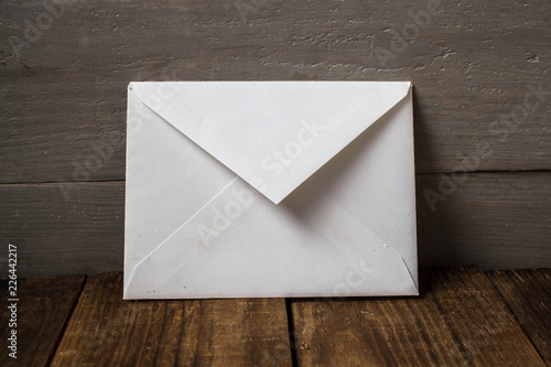 a white envelope on grey wooden background