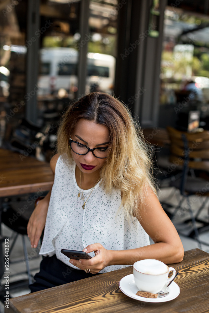 Female in a cafe checking her mobile phone Female in a cafe checking her mobile phone