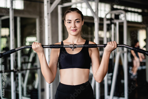 Cinematic tone of young attractive fitness woman exercise with machine in gym. Individual sport to fit muscles of body for healthy life concept. 