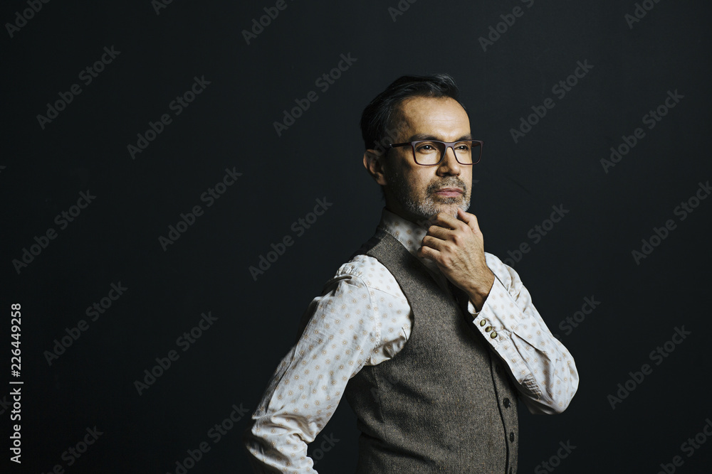 Fototapeta premium Portrait of a mature man thinking, isolated on black studio background