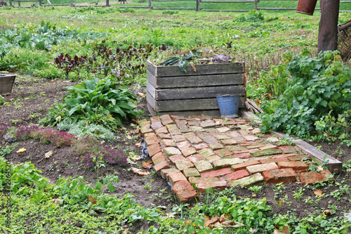 Seasonal work in the autumn garden concept. Container for wooden planks photo