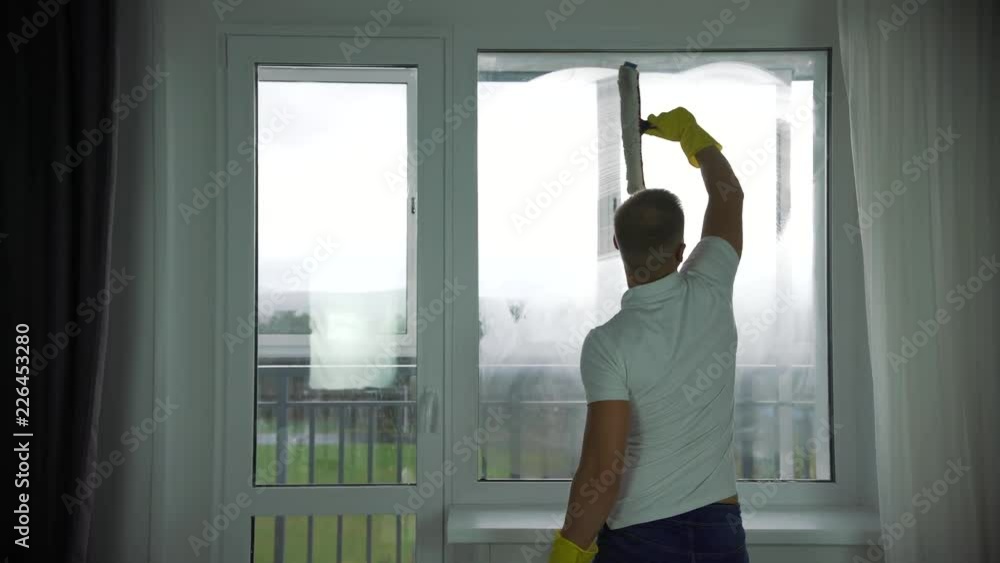 A man from a cleaning company washes Windows A man from a cleaning company washes Windows