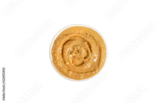 White bowl of creamy peanut butter isolated on white background. Top view. Flat lay.