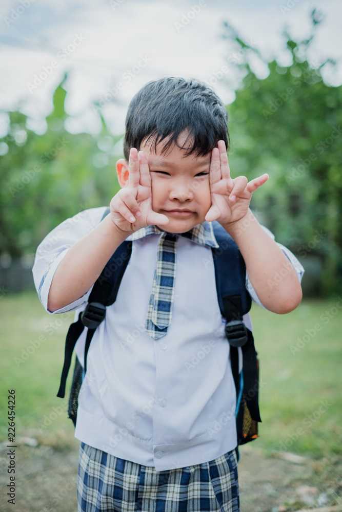Happy children go back to school.Asian smiling boy with two fingers up going to school for the first time.