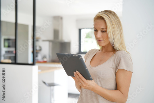 Middle-aged woman at home connected with digital tablet