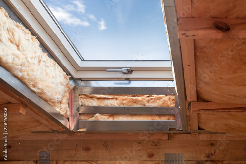 Plastic (mansard) or skylight window on attic with environmentally friendly and energy efficient thermal insulation rockwool.