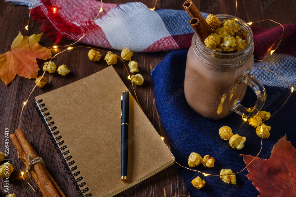 Obraz premium cocoa with popcorn and cinnamon on a slate background with lights