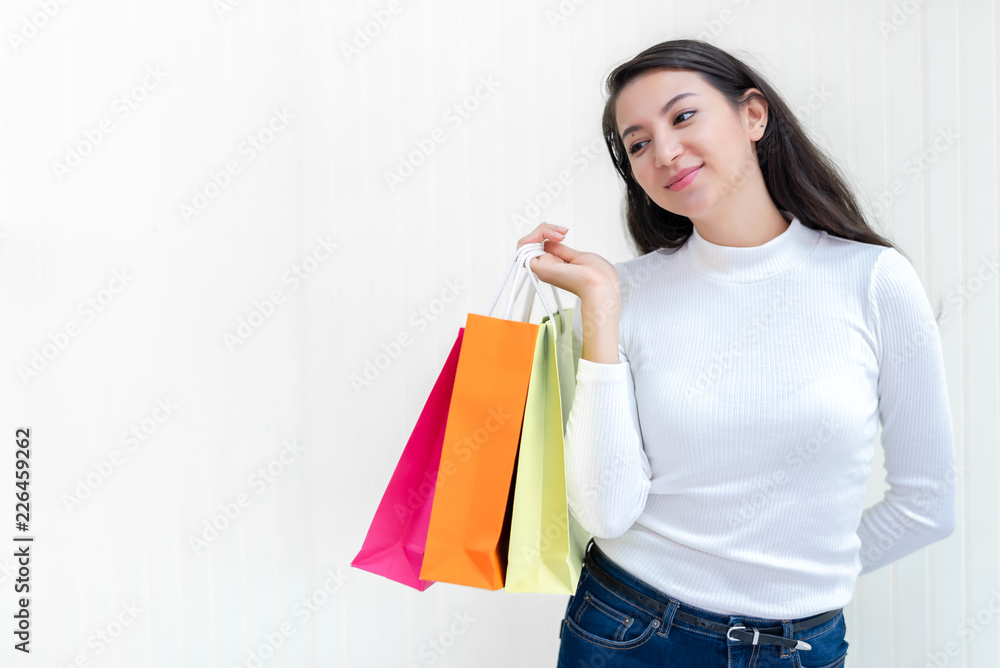 Beautiful attractive Asian female enjoy shopping with full of bags on sale with happiness and joyful. Studio shot on white background. 