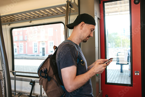 A tourist on the train uses a mobile phone to call or send a message or view a map or mobile application.
