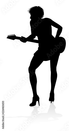A female guitarist musician in detailed silhouette playing her guitar musical instrument.