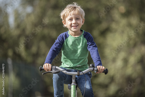 Smiling little boy ride on a bicycle