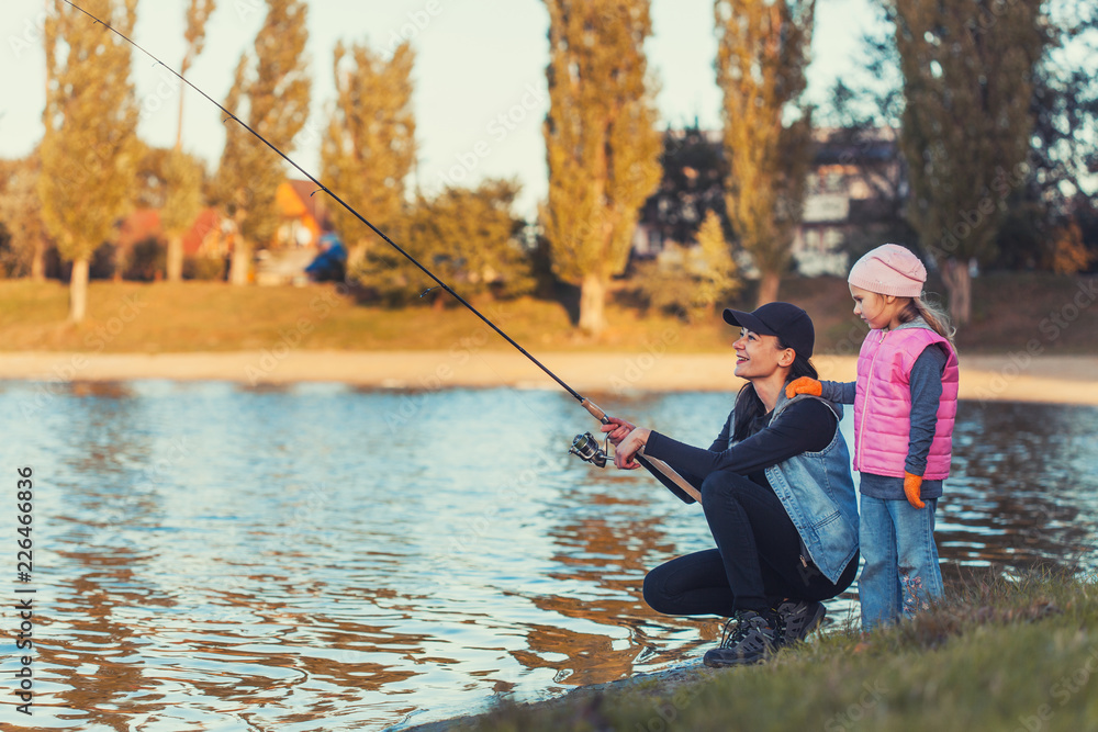 mother and daughter are fishing on the lake. mother and daughter are fishing on the lake.