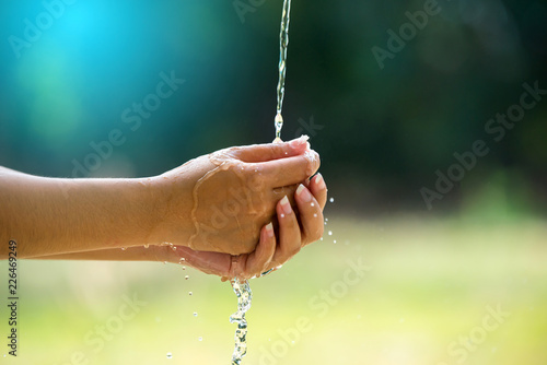 Water pouring in people hand on nature background environment issues.Health care concept.