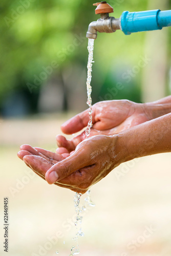 Water pouring in people hand on nature background environment issues.Health care concept.