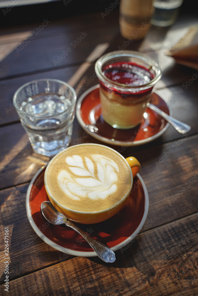 close-up of woman's hands with a cup of coffee cake, the sun's rays shine through a window in the cafe. Hand and cup coffee. close-up of woman's hands with a cup of coffee cake, the sun's rays shine through a window in the cafe. Hand and cup coffee.