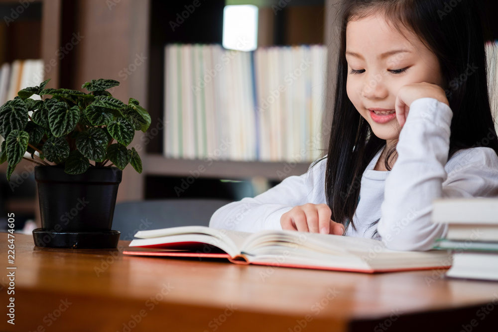 cute girl smiled and standing reading book in the library, children concept, education concept cute girl smiled and standing reading book in the library, children concept, education concept