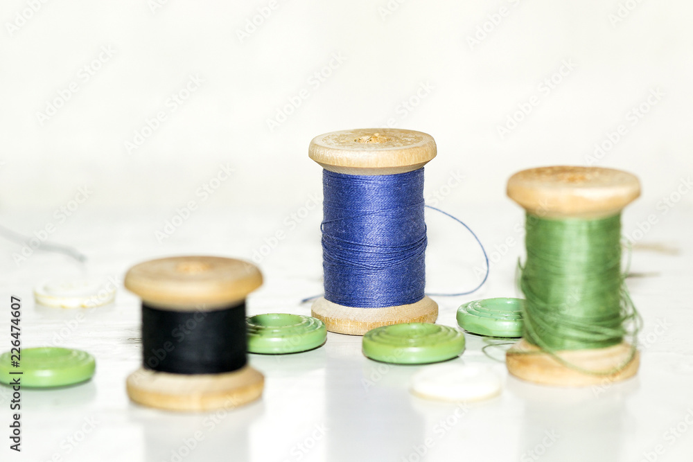 wooden coils with blue and green threads and lots of green butto wooden coils with blue and green threads and lots of green butto