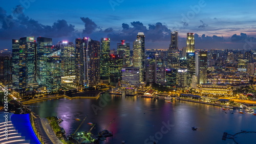 A view of Singapore business district skyscrapers at evening with water reflections day to night